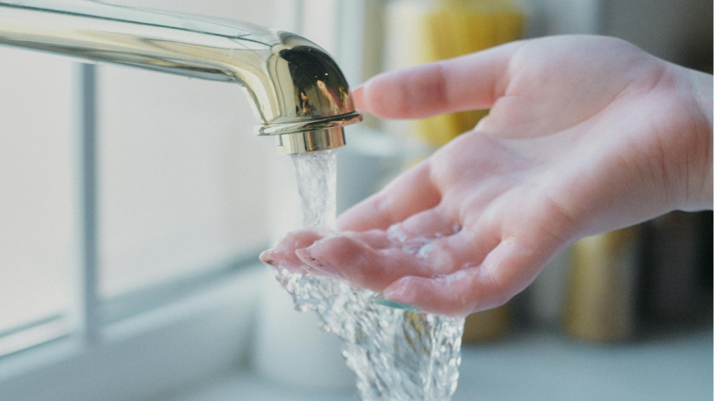 Une main qui touche l'eau du robinet