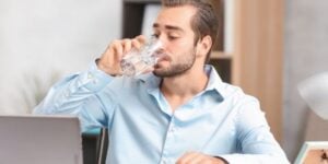 Employé qui boit de l'eau au bureau