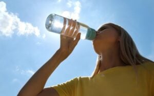Femme qui boit de l'eau à la bouteille – filtre eau UV