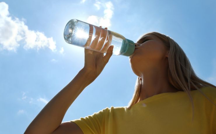 Femme qui boit de l'eau à la bouteille – filtre eau UV